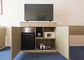 A hotel room with a minibar, a television, a refrigerator, a coffee maker, and a safe. - Holiday Inn Córdoba by IHG (Córdoba)