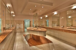 A modern bathroom with a central island sink, multiple mirrors, and a tiled floor. - Holiday Inn Córdoba by IHG (Córdoba)