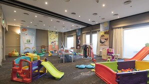 Uma área de recreação infantil com escorregadores, mesas de jogos e estruturas coloridas.