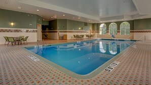 An indoor swimming pool with clear lane markings, a tiled floor, and a seating area with chairs. - Holiday Inn Hotel & Suites-Milwaukee Airport by IHG (Milwaukee)