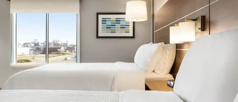 Habitación de hotel con una cama grande, una mesita de noche, una lámpara y un cuadro en la pared.