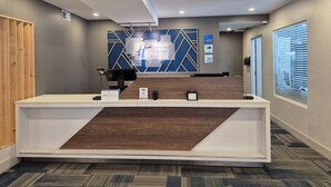 A reception desk with a modern design, a check-in counter, and a wall-mounted sign indicating 'Holiday Inn Express'. - Holiday Inn Express Dryden by IHG (Dryden)