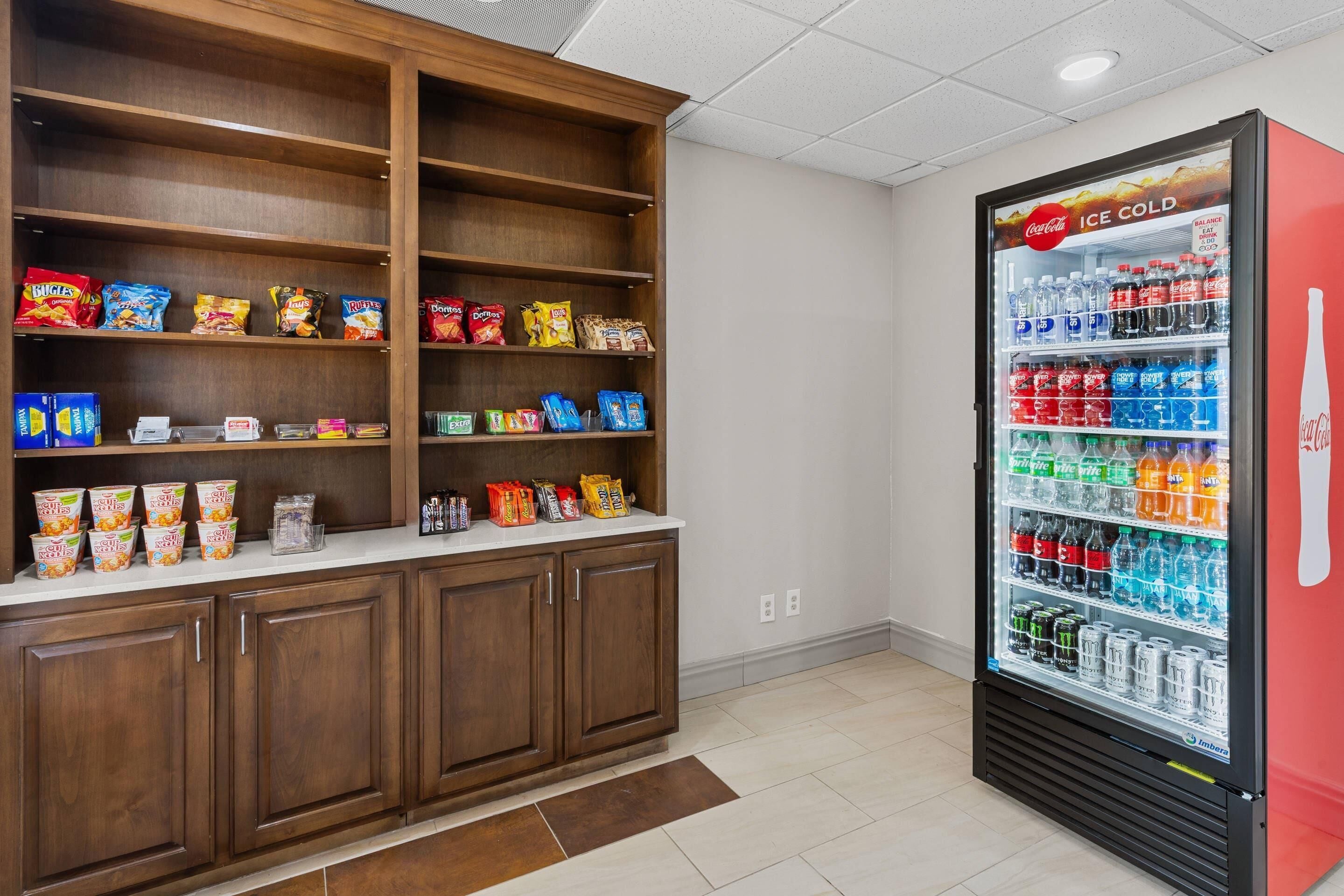 A snack bar with a Coca-Cola refrigerator and wooden cabinets.