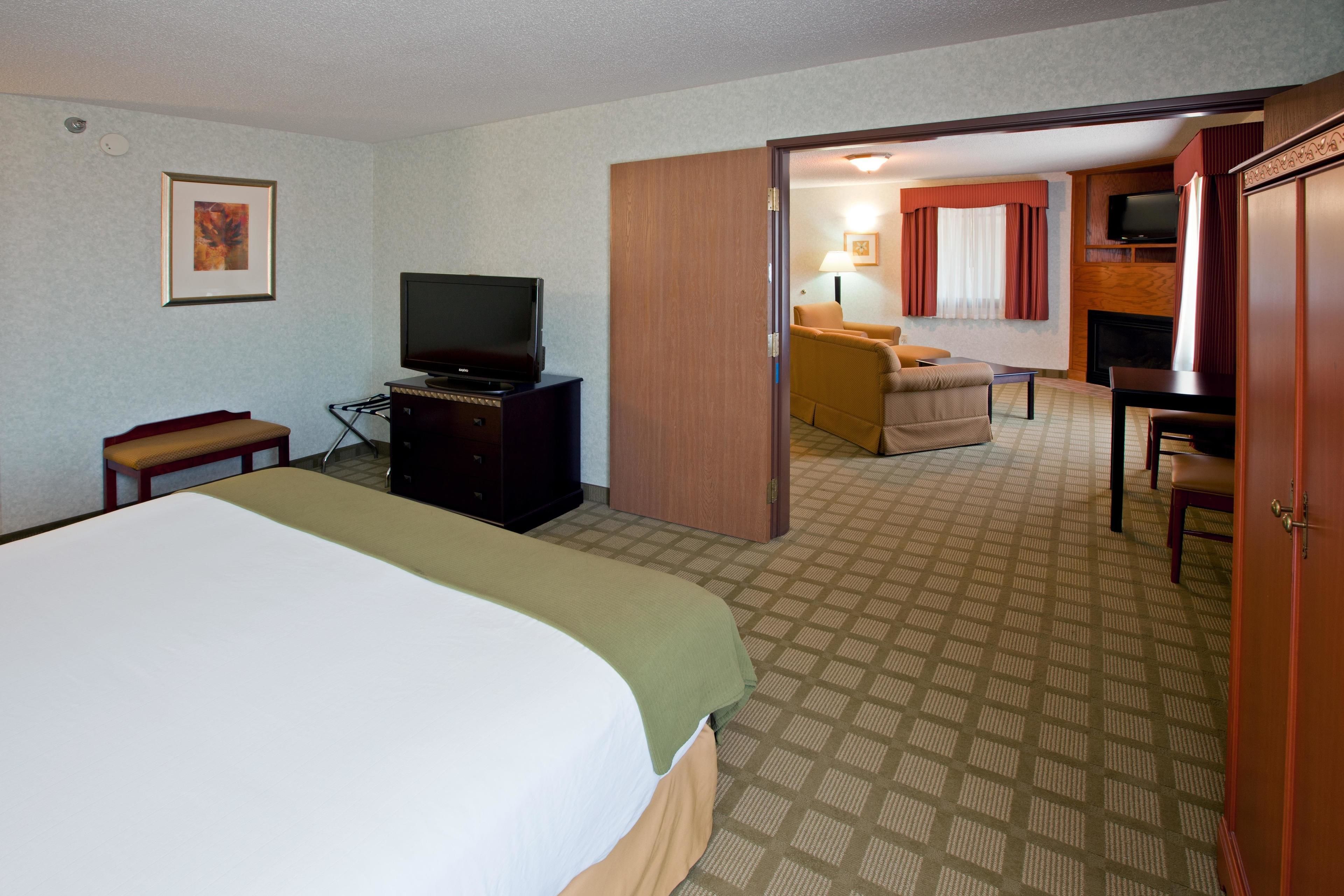 A hotel room with a bed, a television, a desk, and a chair.