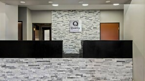 Uma área de recepção com parede de pedra e um letreiro que diz "Quality by Choice Hotels".