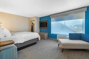 A hotel room with a bed, a seating area, a TV, and a window. - Holiday Inn Express St. Croix Valley by IHG (St Croix Falls)