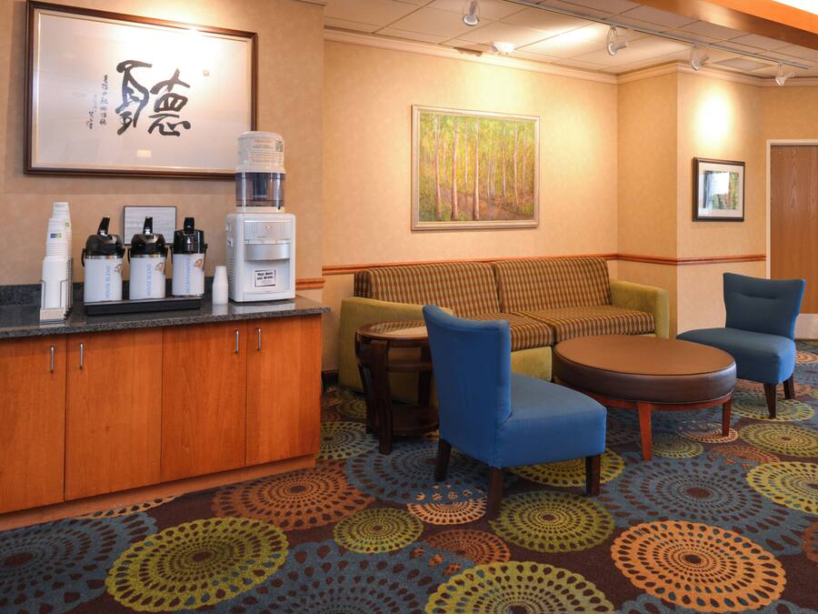 A hotel lobby with a reception desk, seating area, and a door labeled 'Sales & Marketing Manager'.