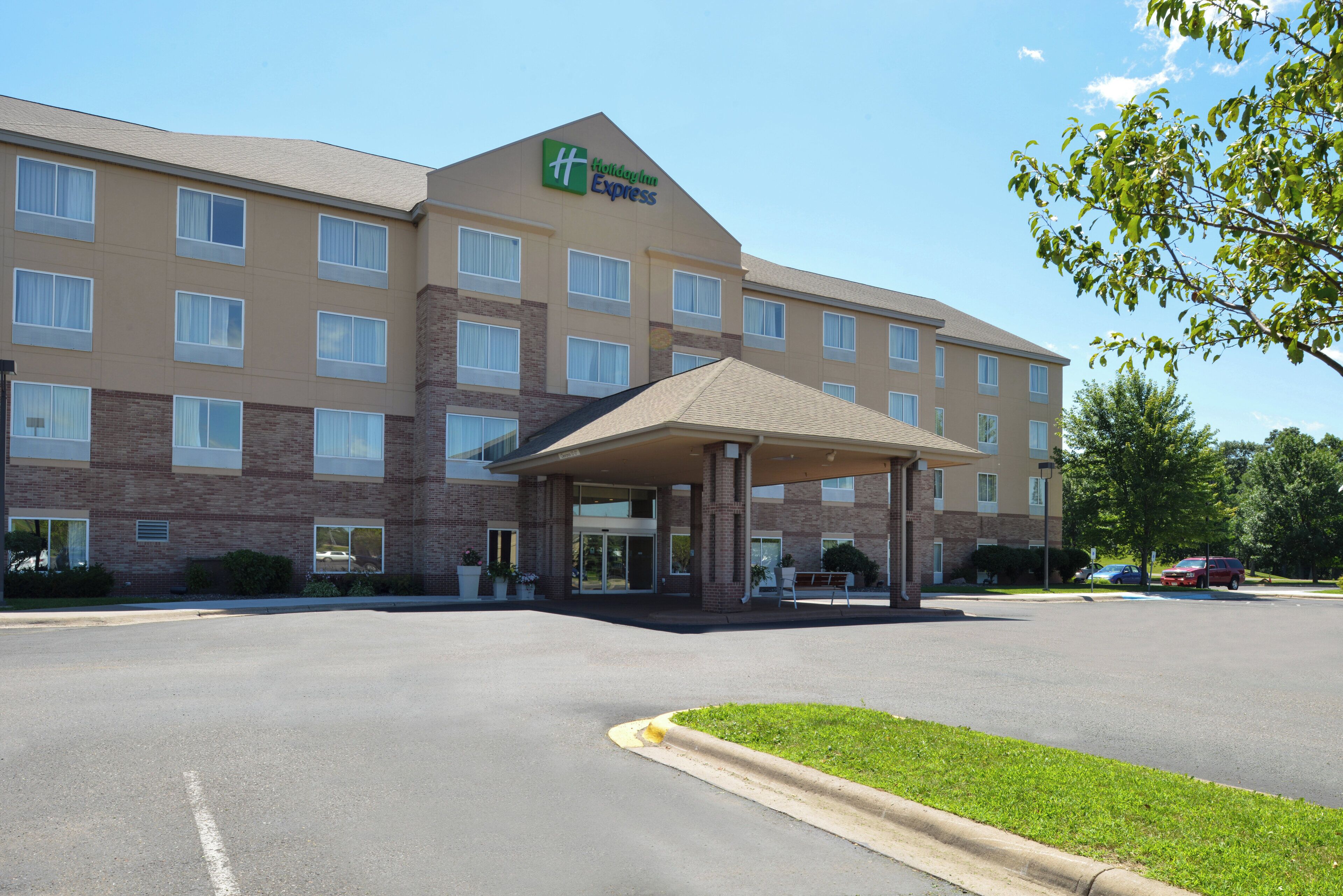 A Holiday Inn Express hotel with a covered entrance, multiple windows, and a parking lot.
