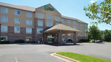 A Holiday Inn Express hotel with a covered entrance, multiple windows, and a parking lot.