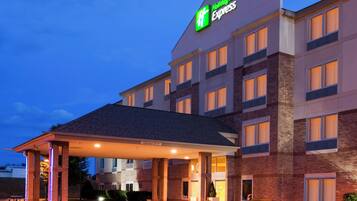 Un hotel Holiday Inn Express con entrada cubierta, varios pisos y fachada de ladrillo.