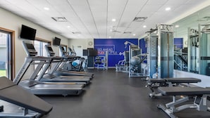 A gym with treadmills, weight machines, and a motivational wall.