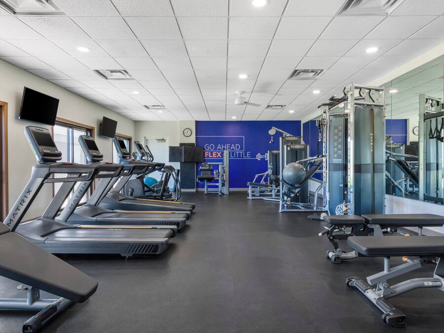 A gym with treadmills, weight machines, and a motivational wall.