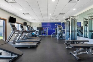 A gym with treadmills, weight machines, and a motivational wall.