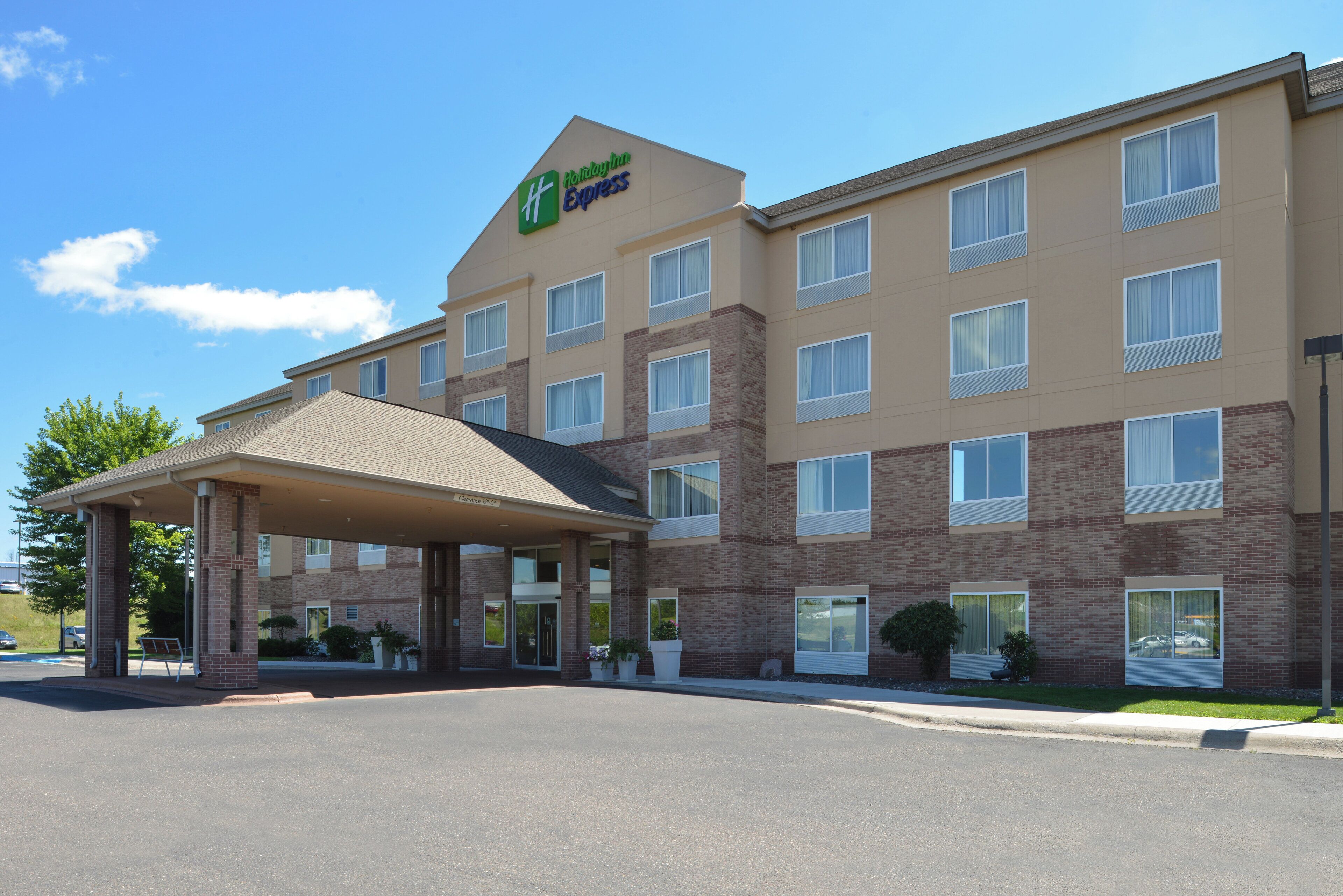 Een Holiday Inn Express gebouw met een overdekte ingang, meerdere ramen en een gevel van baksteen.