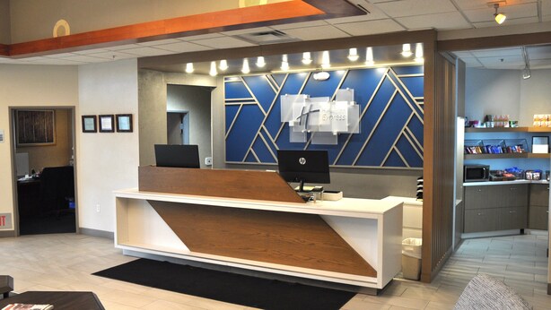 A reception desk with a modern design, a computer, and a counter with a menu.