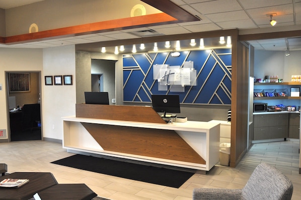 A reception desk with a modern design, a computer, and a counter with a menu.