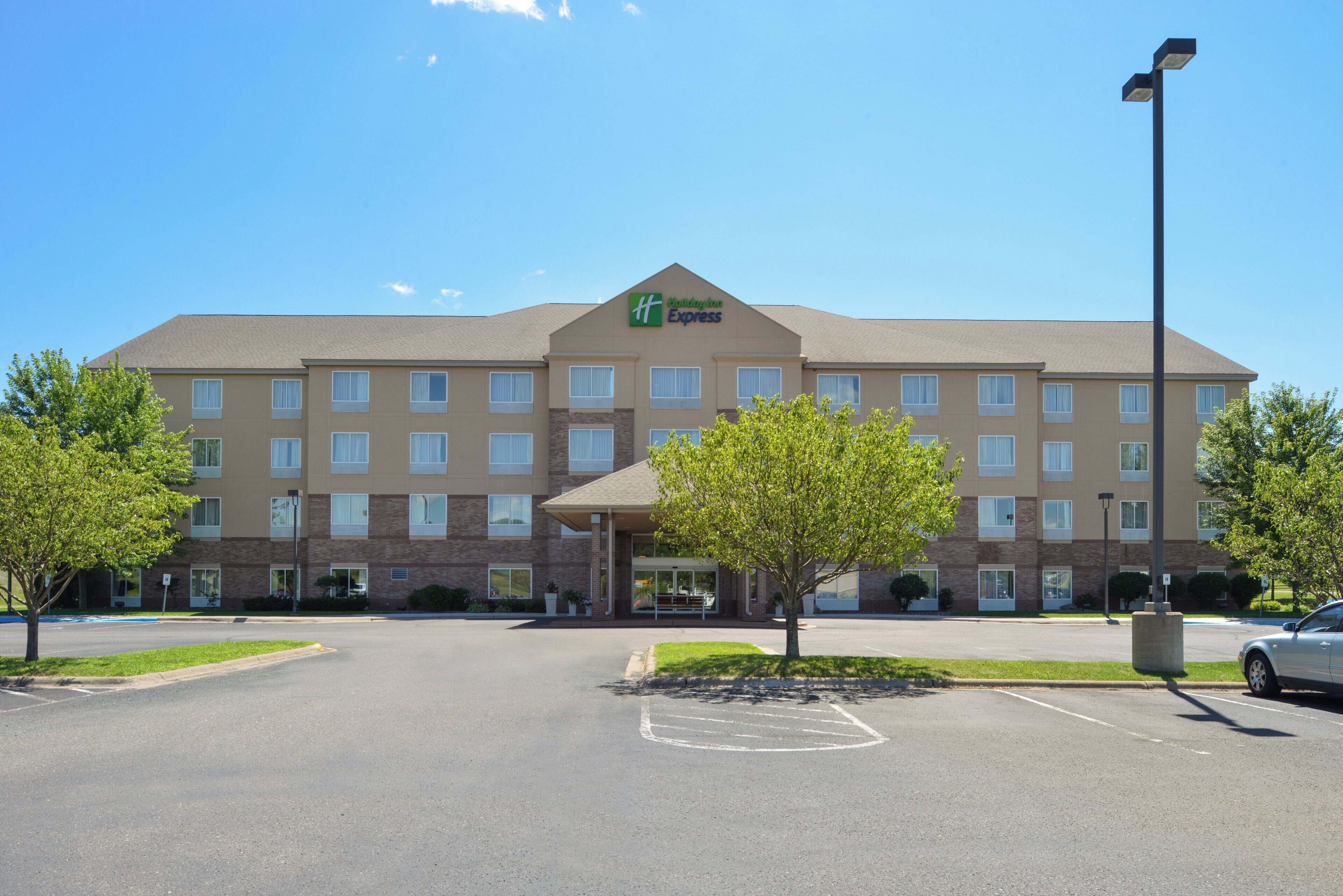A Holiday Inn Express hotel with a central entrance, multiple floors, and a parking lot.