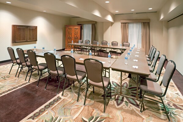 A conference room with a long table, chairs, and water bottles.