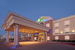 Edificio de Holiday Inn Express con entrada cubierta, fachada de ladrillo y varias ventanas.