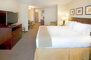 A hotel room with a large bed, a TV on a wooden dresser, a desk, and a chair.