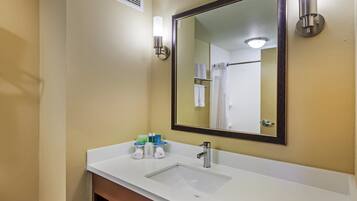 A bathroom with a white sink, a mirror, and two wall-mounted lights.