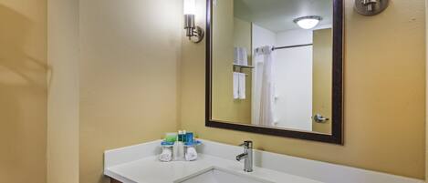 A bathroom with a white sink, a mirror, and two wall-mounted lights.