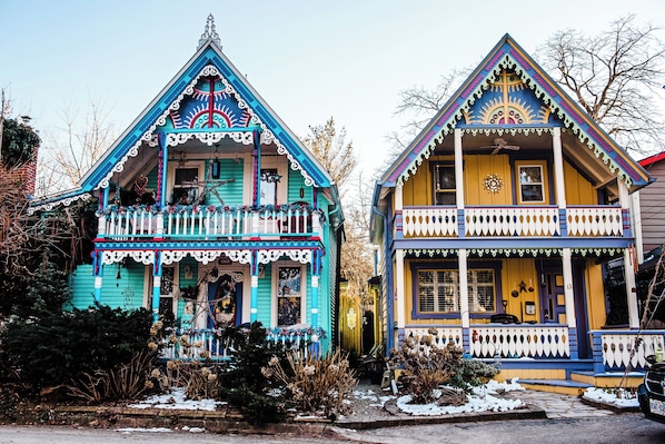 Two colorful houses with distinct architectural styles, featuring balconies and decorative elements.