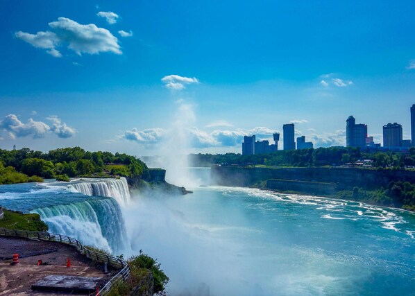 A waterfall with a city skyline in the background.