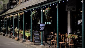 An outdoor café with tables and chairs, a menu board, and a sign for 'Dukes Coffee House'. - The Bedford Hotel (Tavistock)
