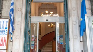L'ingresso dell'Hotel Cecil, caratterizzato da un'imponente arcata, un lampadario e una scalinata che conduce all'interno.