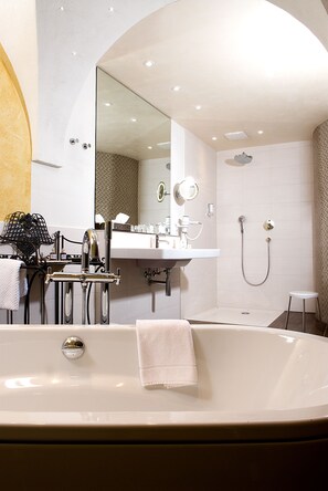 A modern bathroom with a freestanding bathtub, a vanity with a mirror, and a shower area. - Hotel & Brauereigasthof Drei Kronen (Memmelsdorf)