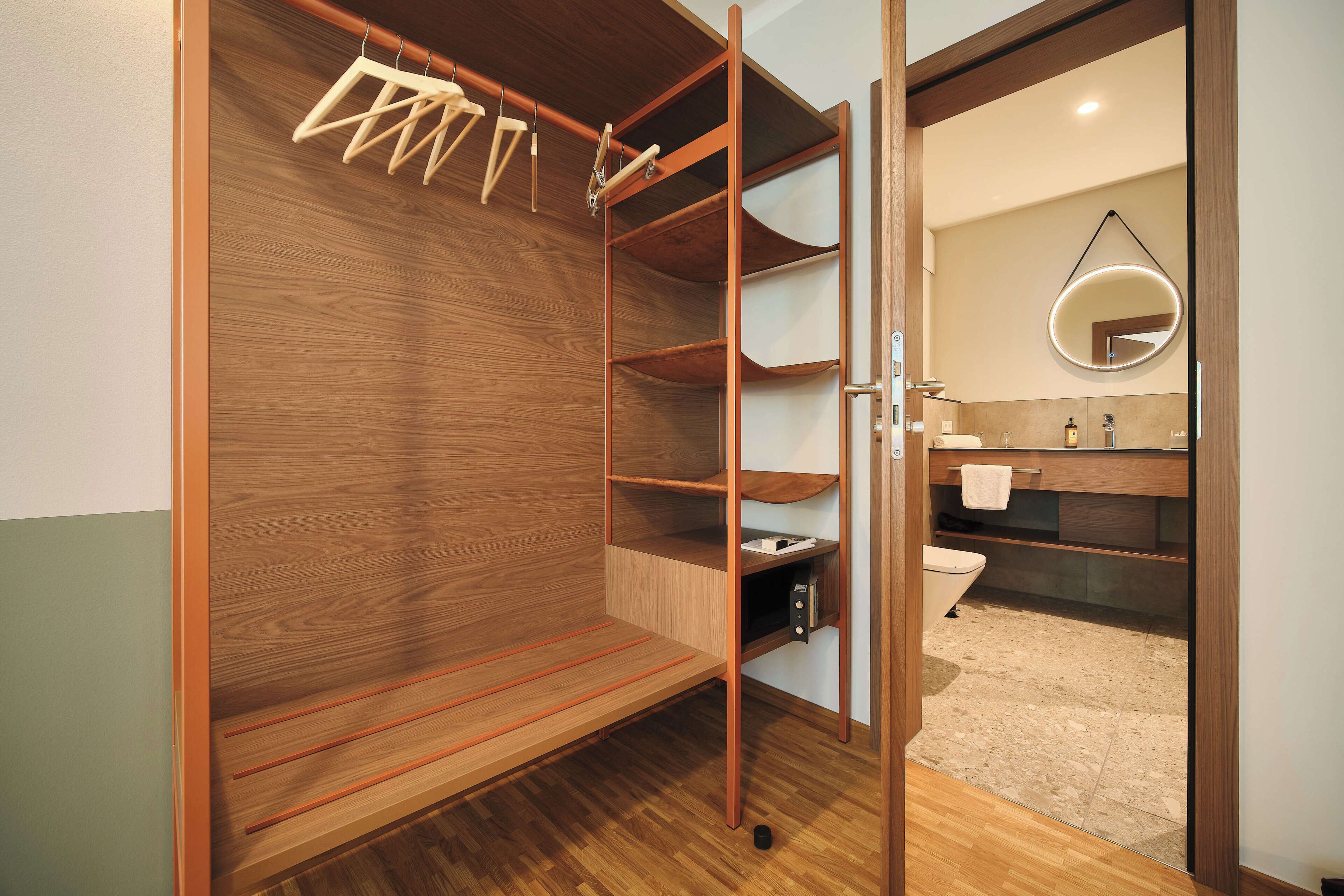 Un vestidor con repisas de madera y una barra para colgar.