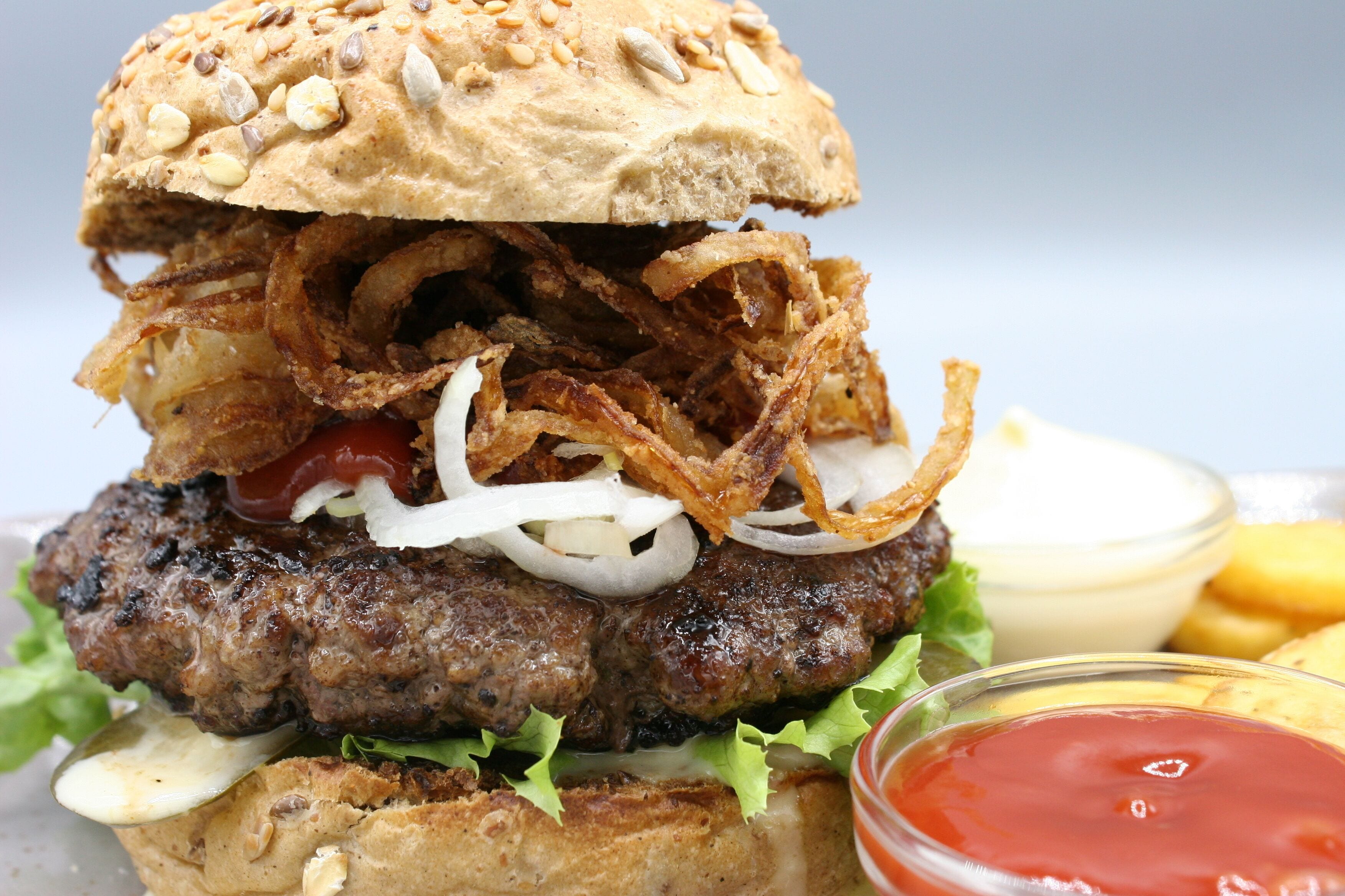 Ein Burger mit Salat, Zwiebeln und einem Brötchen.