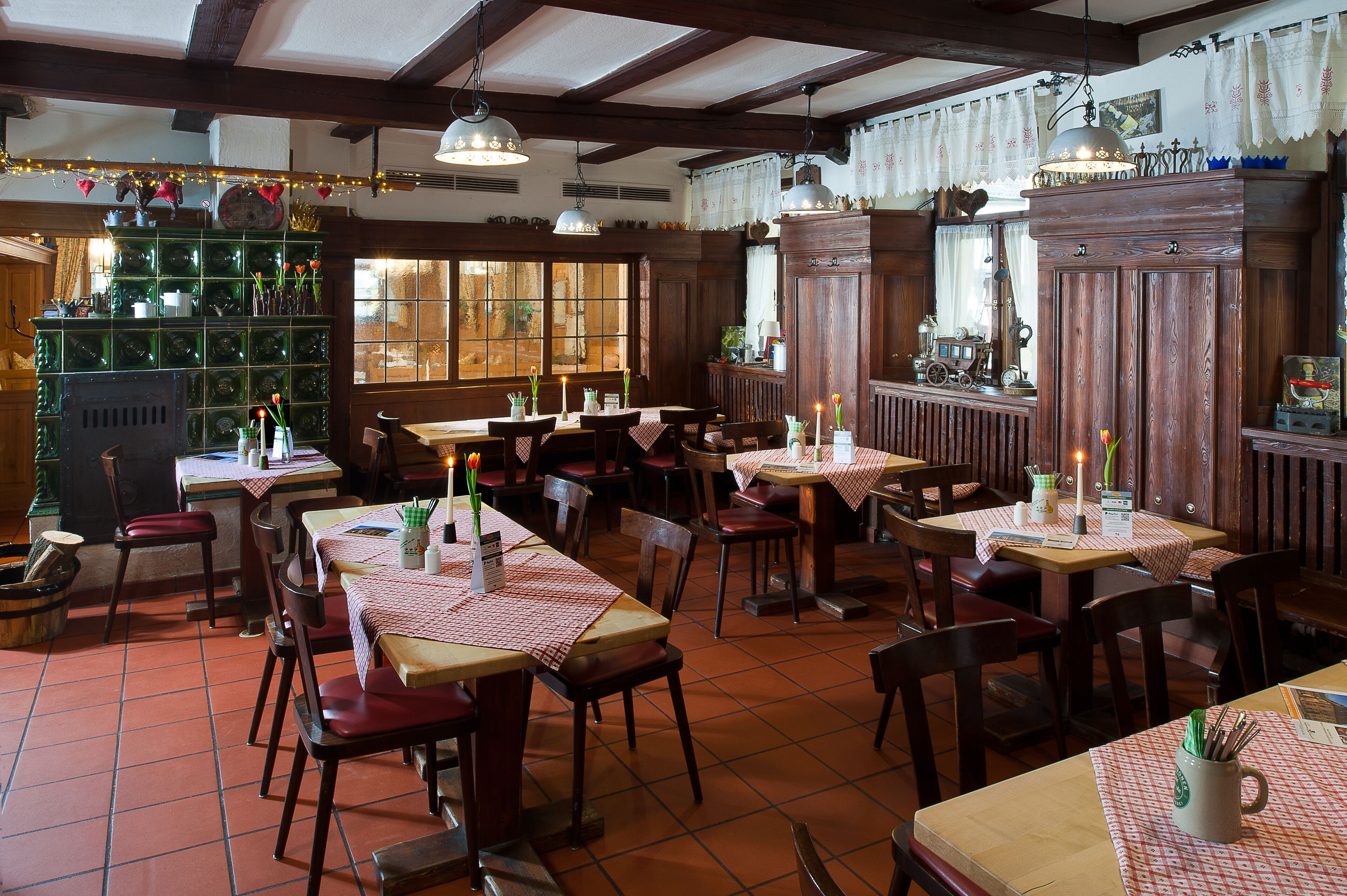 A restaurant with wooden tables and chairs, a tiled floor, and a rustic decor.