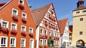 A traditional half-timbered building with flower boxes and a sign for a restaurant. - Hotel Garni Am Ellinger Tor (Weissenburg in Bayern)