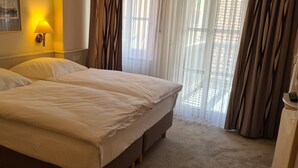 A double bed with white linens in a hotel room. - Hotel Garni Am Ellinger Tor (Weissenburg in Bayern)