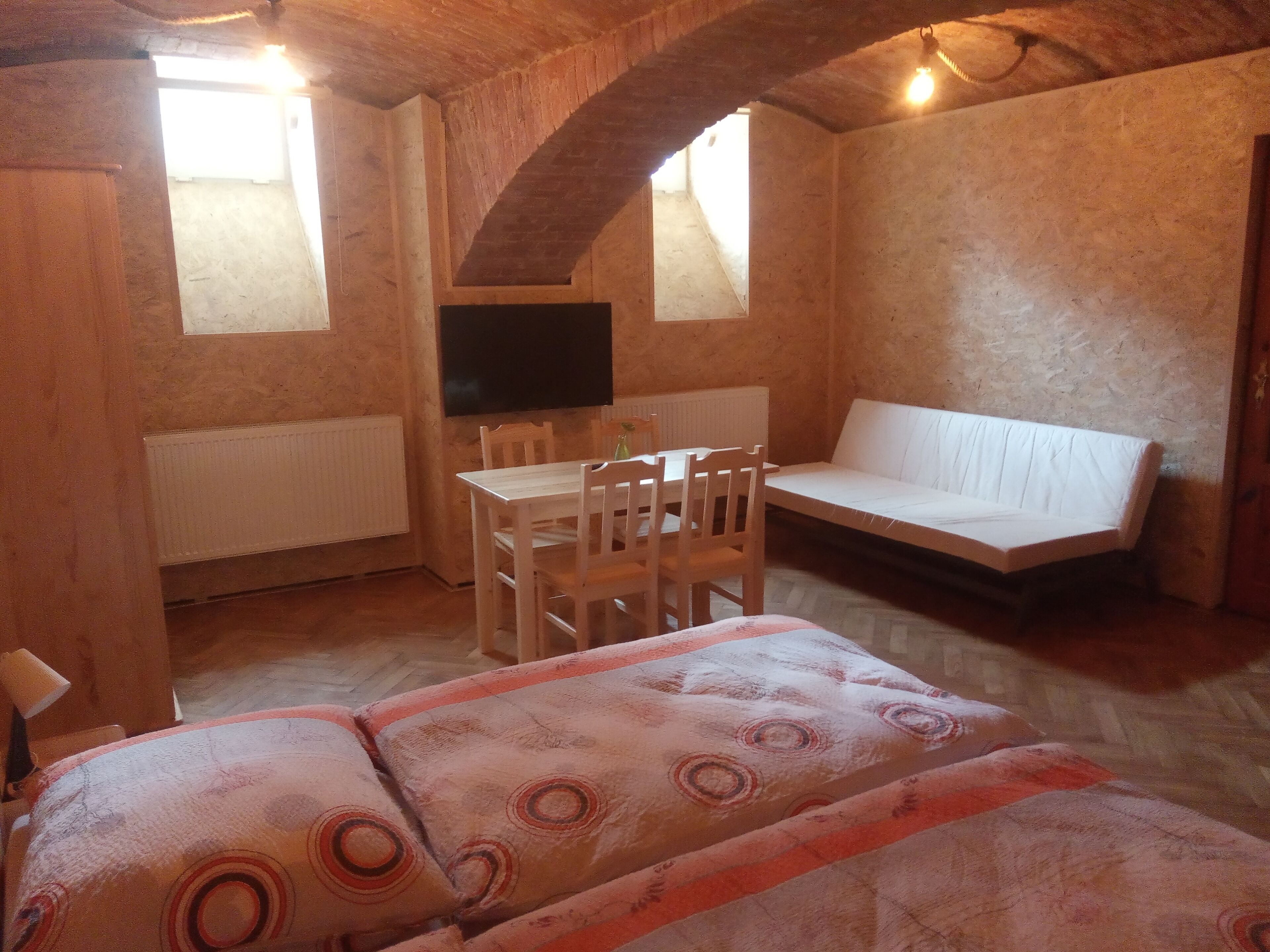 Una habitación acogedora con una mesa de madera, sillas, un sofá y un televisor.