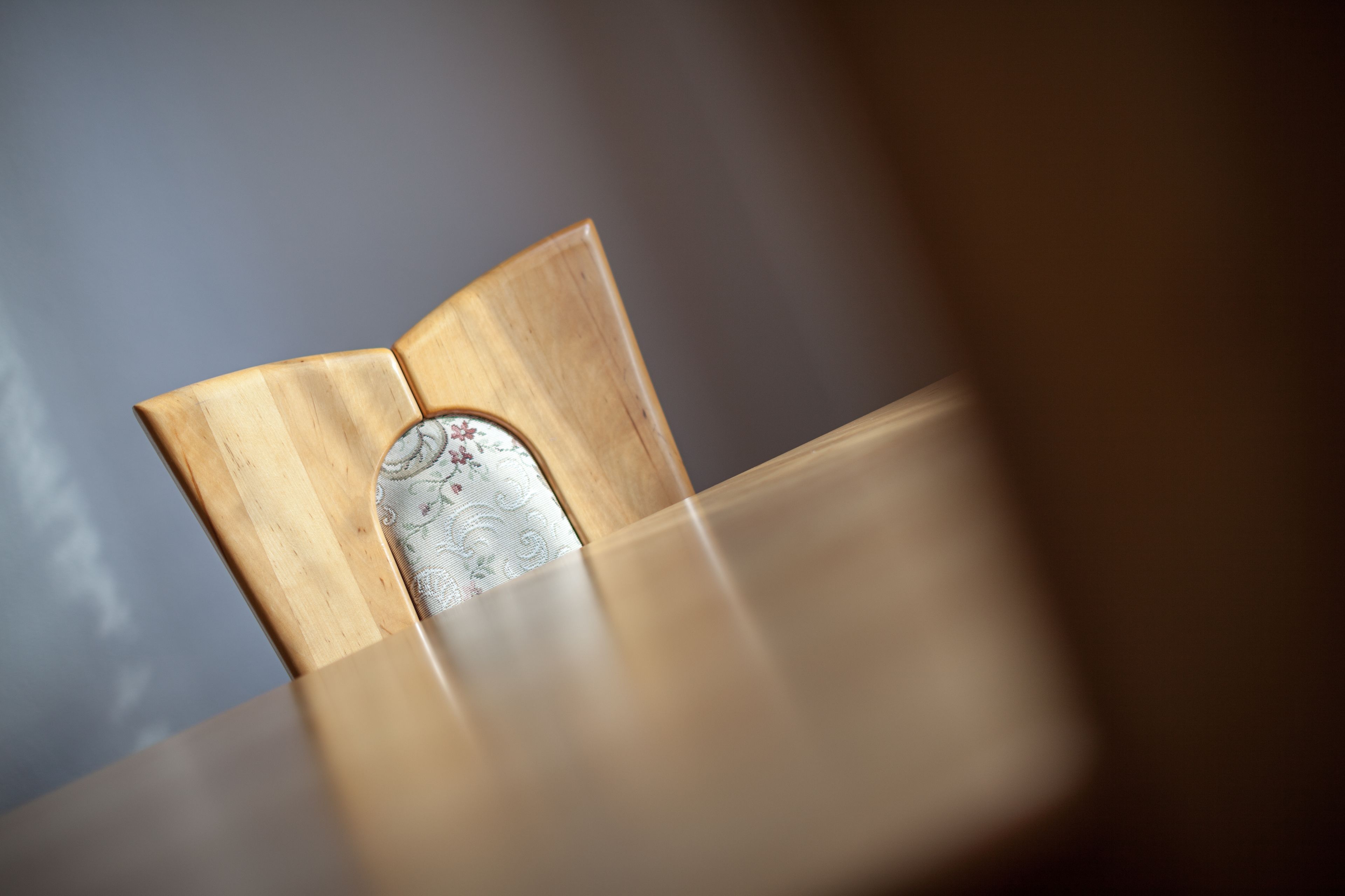 Een houten stoel met een kussen met een patroon.
