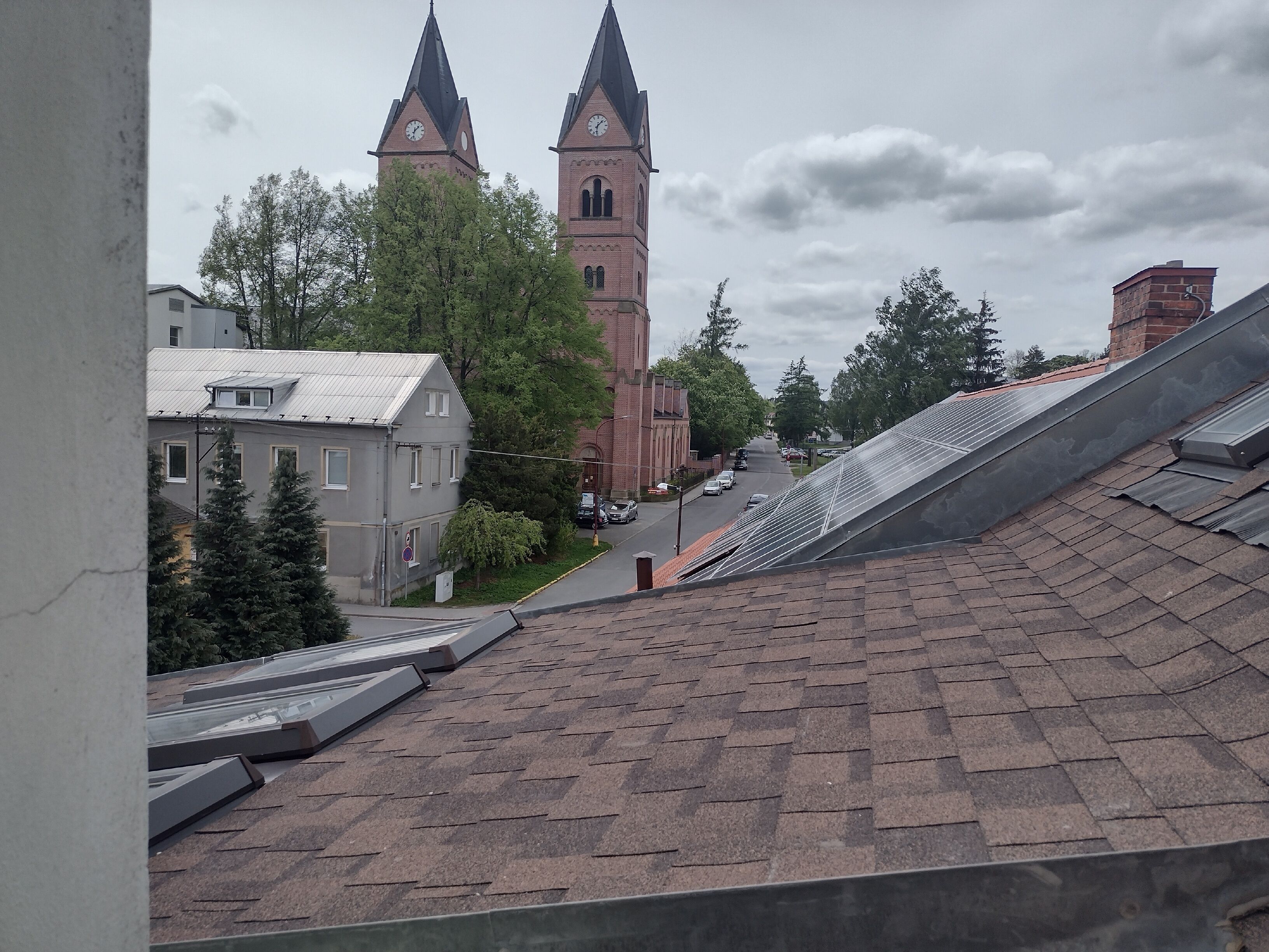 A view of a church with two towers and a street in the foreground.