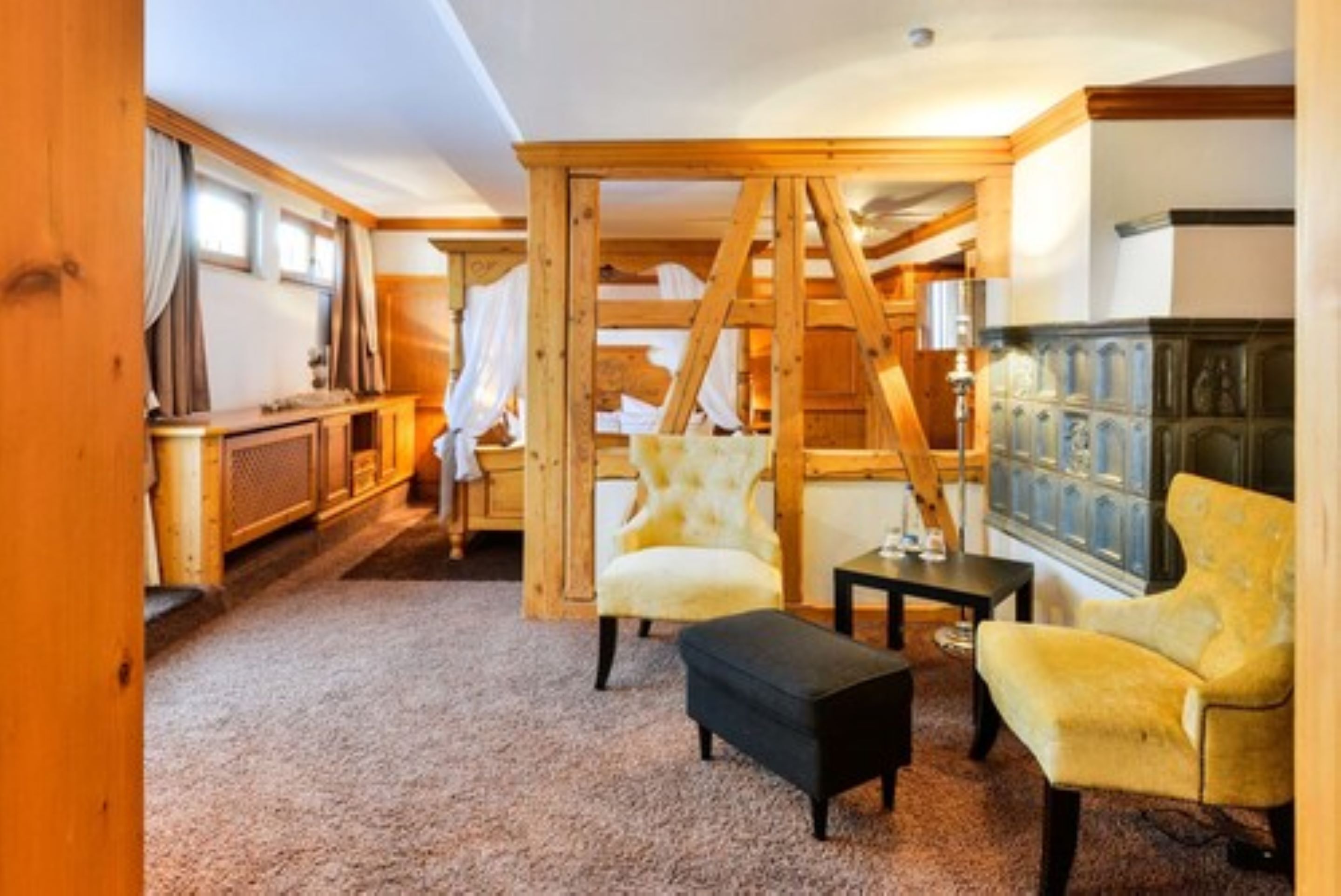 A cozy room with a wooden ladder, two armchairs, a small table, and a bench.