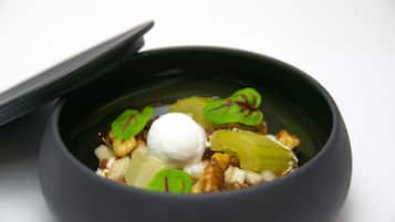 Un plato de comida con una porción de helado y hojas verdes por encima.