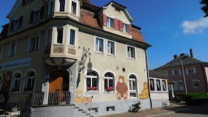 A building with a traditional architectural style, featuring a corner turret, multiple windows, and a balcony. - Teddybärenhotel (Kressbronn)