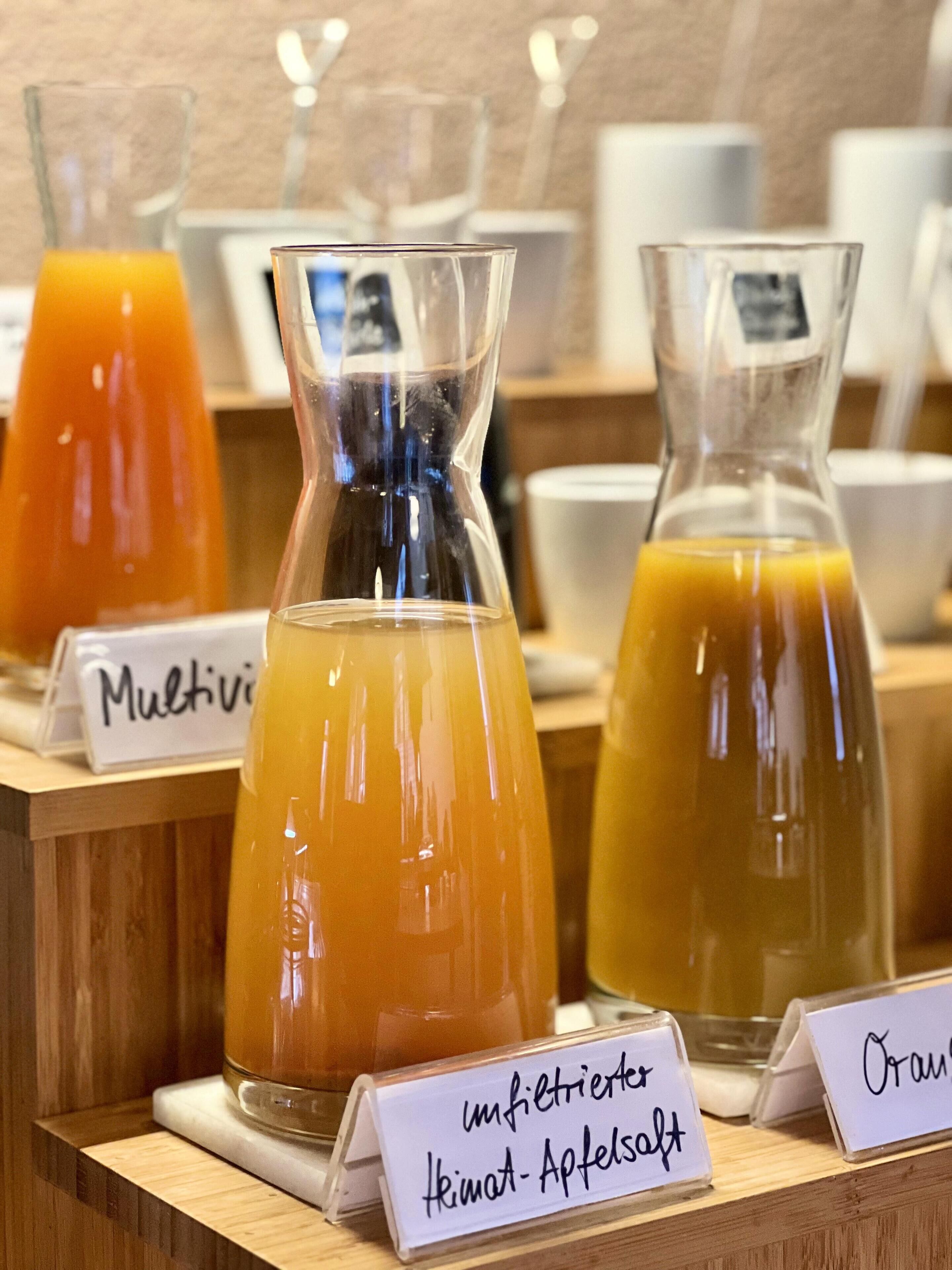 A display of various juices with labels indicating their names.