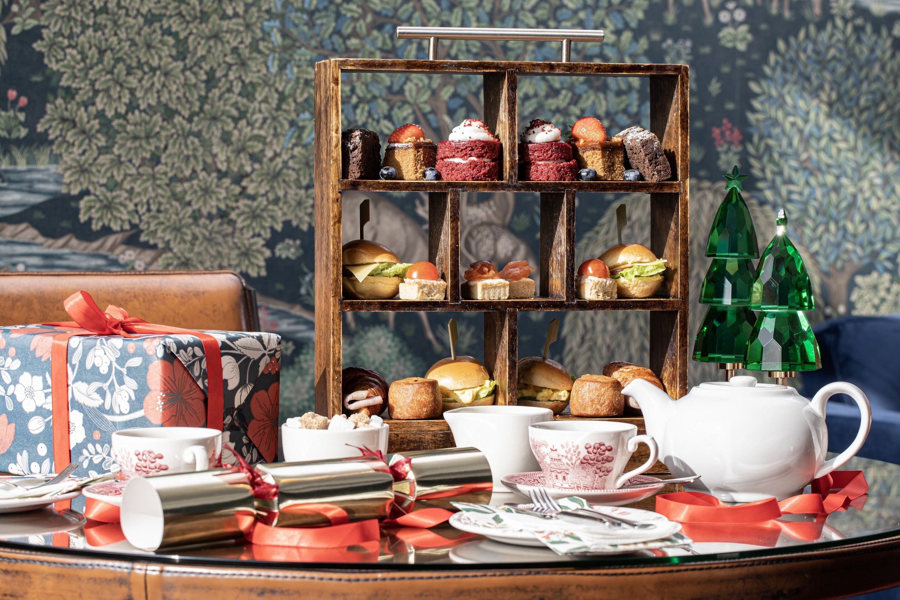 A table set with various pastries, a teapot, and a gift box.