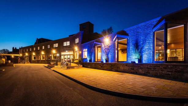 A stone building with a spa hotel sign, a reception area, and a paved entrance.