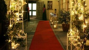 A red carpet leading to a decorated entrance with lights and floral arrangements. - Waterfoot Hotel (Londonderry)
