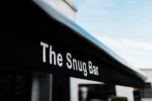 Letrero para "The Snug Bar" con un diseño arquitectónico moderno.