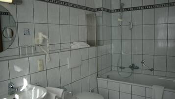 Une salle de bain avec un lavabo, des toilettes et une douche.