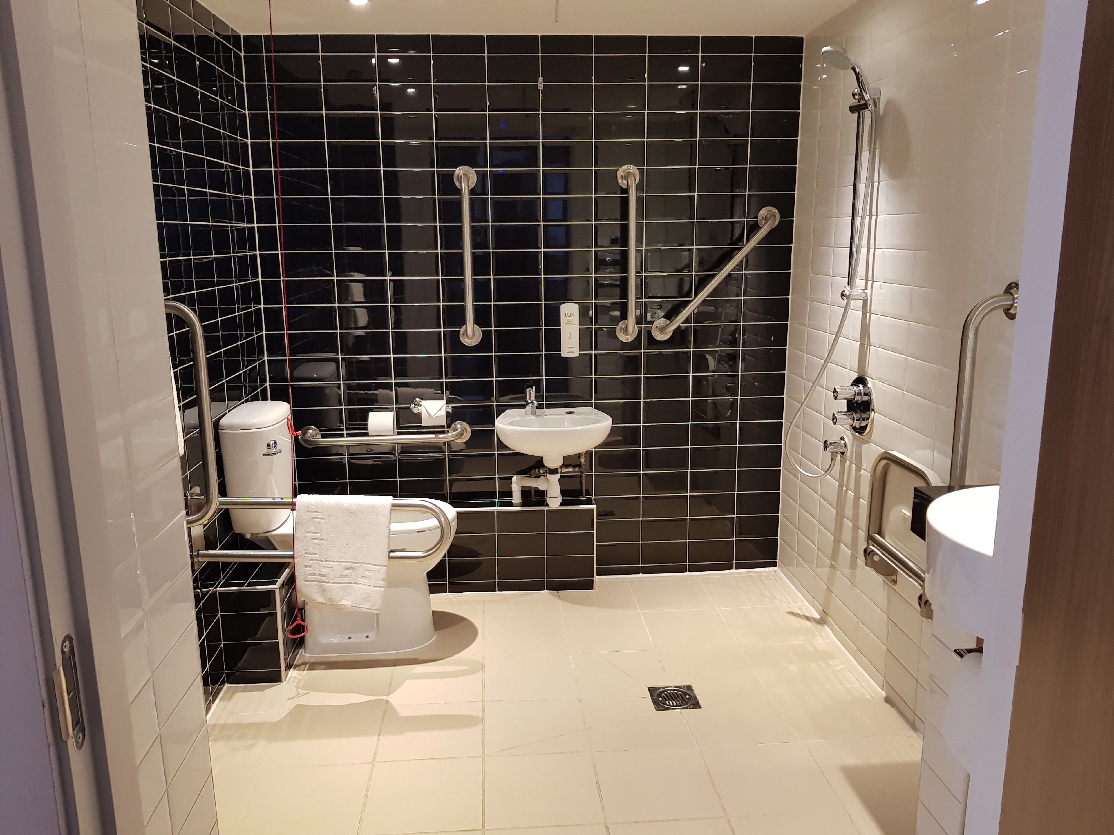 A modern bathroom with a toilet, sink, and shower area.