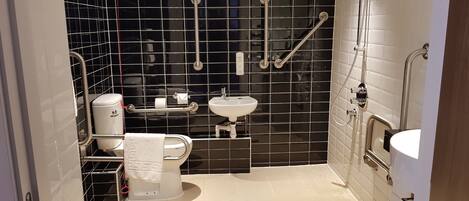A modern bathroom with a toilet, sink, and shower area.